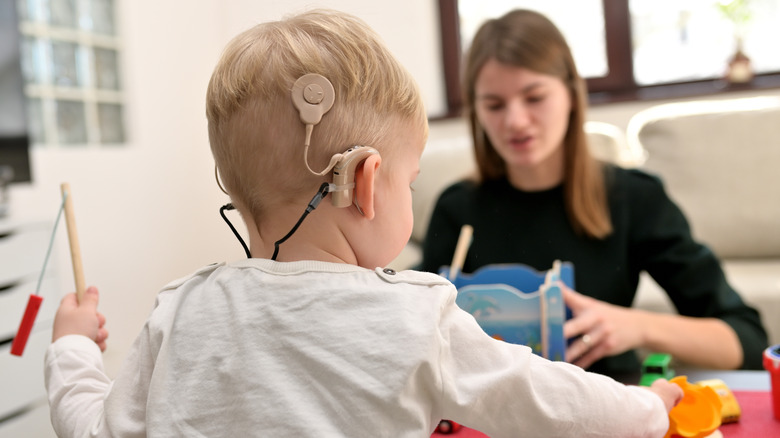 Child with cochlear implants and teacher
