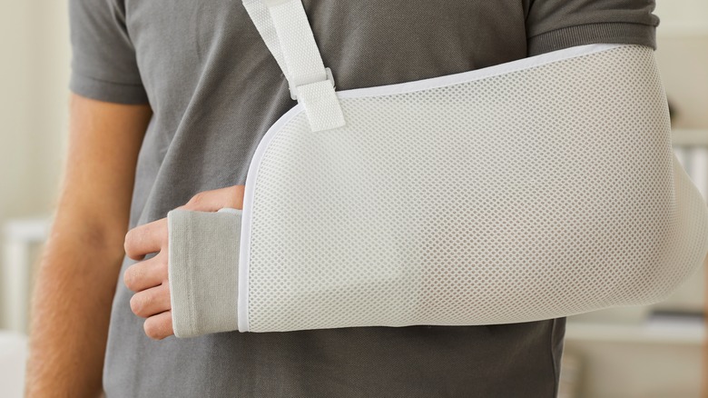 Man with arm injury in cast and sling