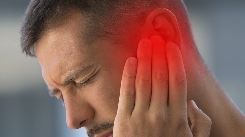 Man with glowing ear in pain