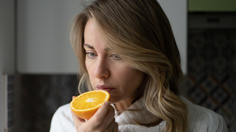 woman trying to eat orange
