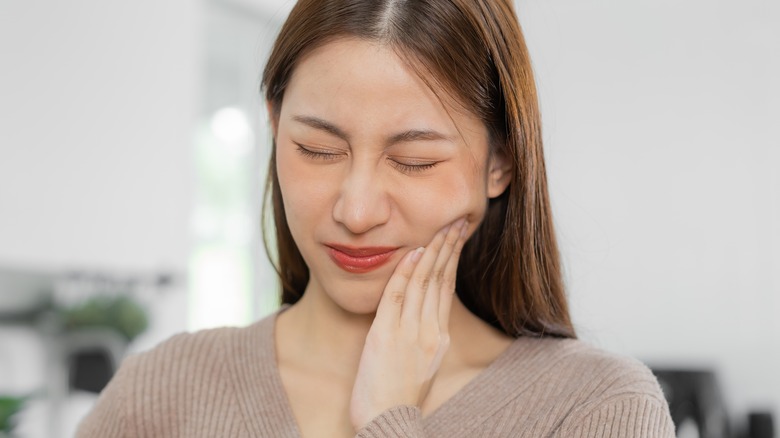 girl holding jaw in pain