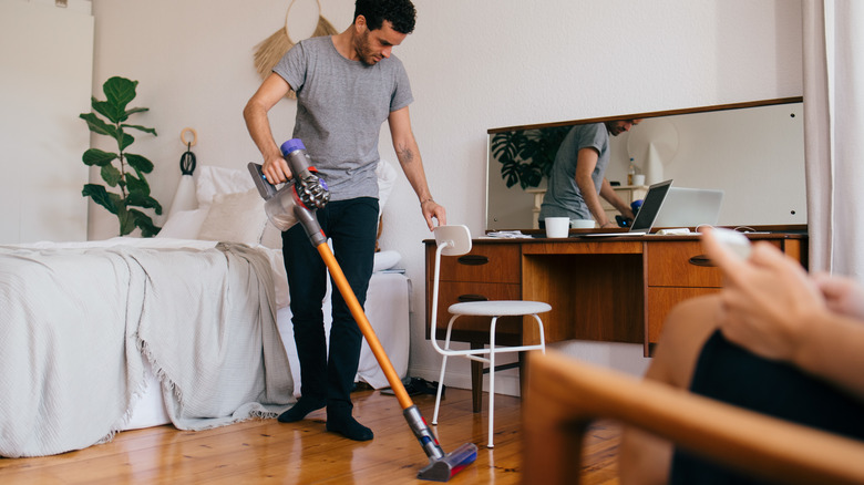 young man cleaning bedroom