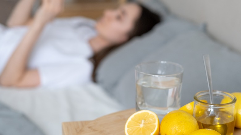 woman in bed near table of lemons