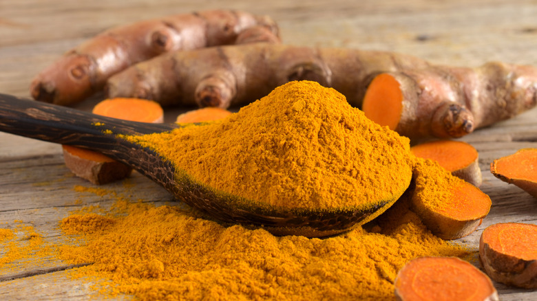 Turmeric powder in a wooden spoon