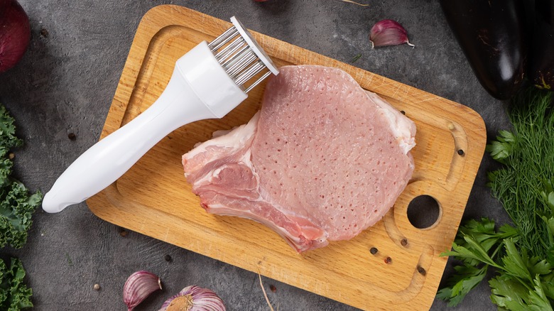 tenderizing meat on a cutting board