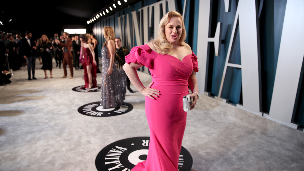 Rebel Wilson posing in a pink evening gown 