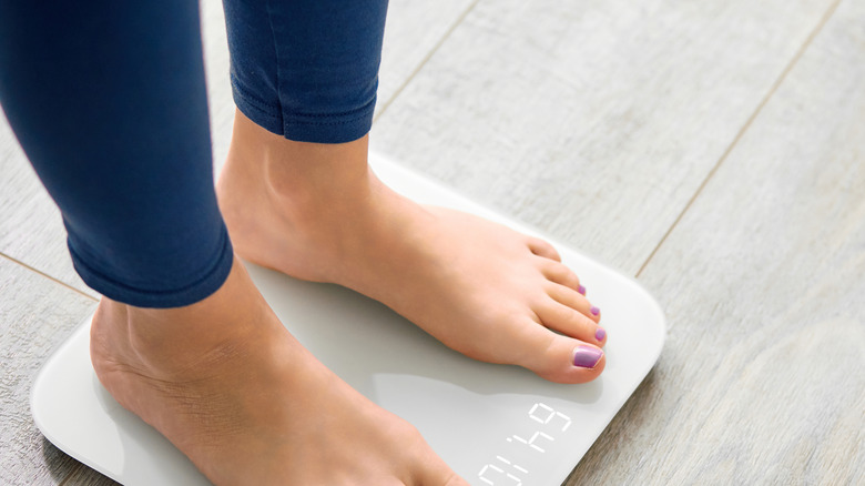 woman standing on weight scale