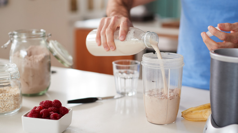 A man makes a protein shake at home