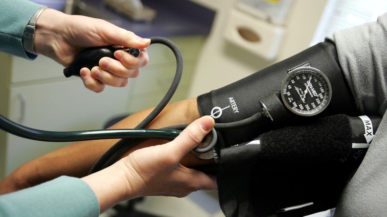 doctor checking man's blood pressure