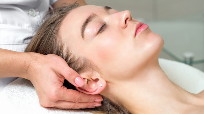 Woman receiving professional ear massage