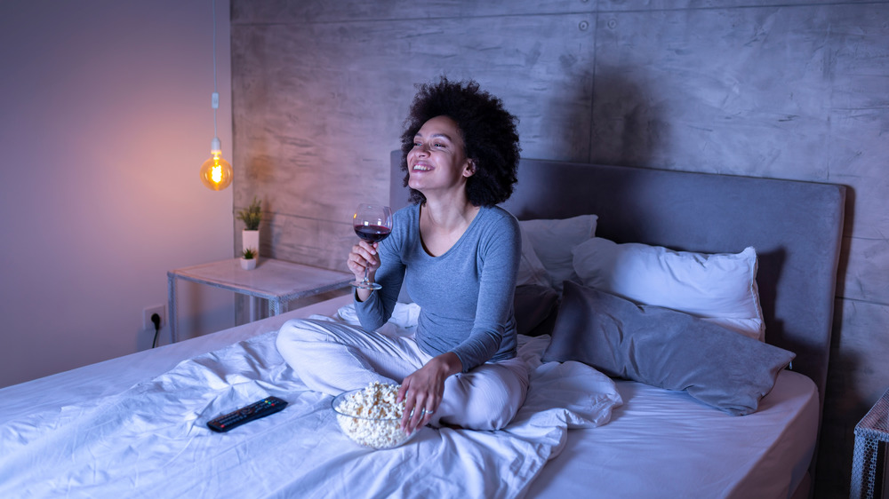 woman drinking wine in bed