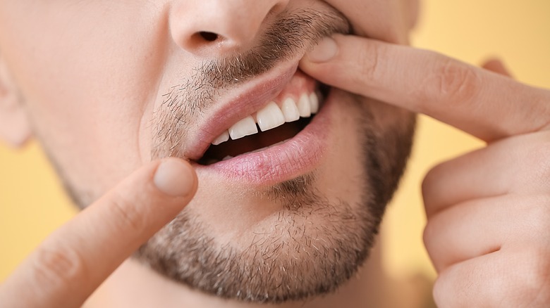 Man with beard poking at his mouth