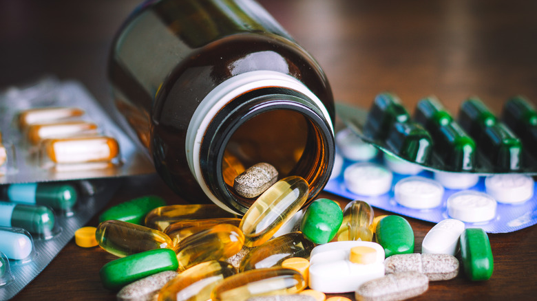 Medicine bottle on its side by different medications