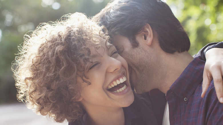 man kissing woman on cheek