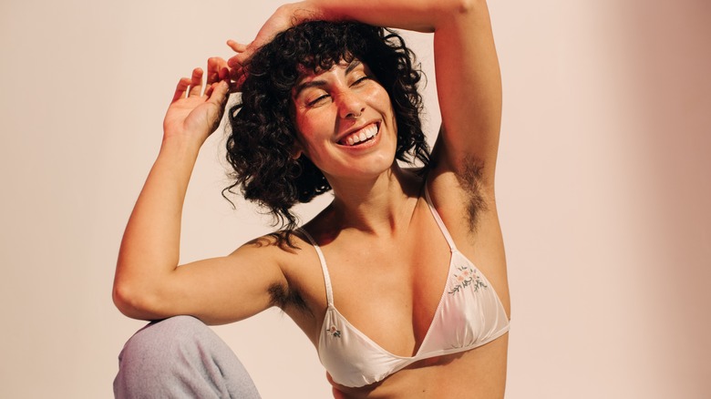 woman wearing a bra and laughing at the camera