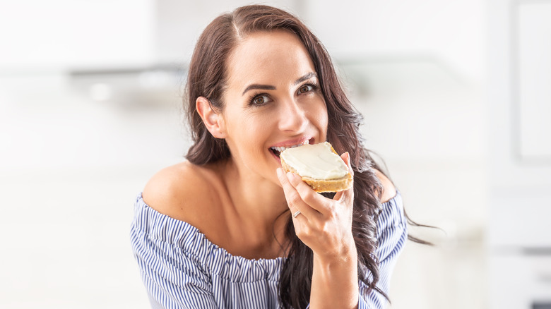 Woman eating butter toast and smiling