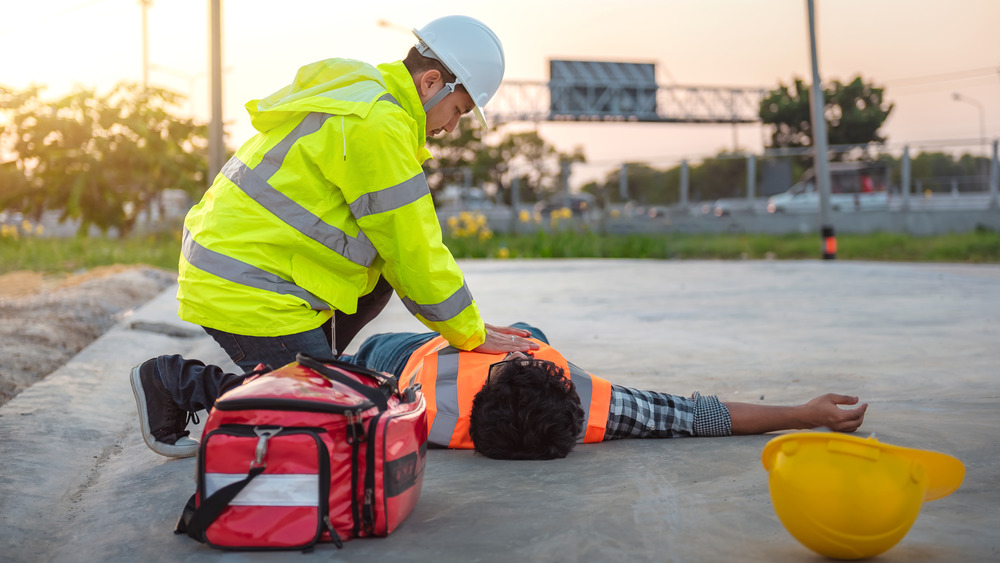 Worker resuscitating unconscious man