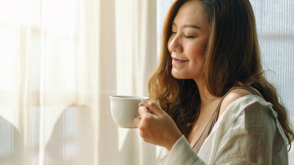 woman enjoying the smell of coffee