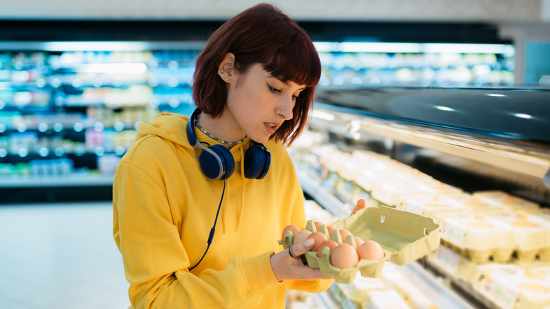 woman inspecting eggs at store