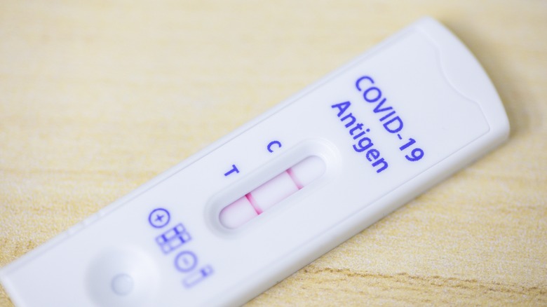 positive COVID-19 antigen test on table