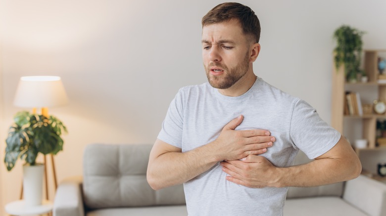 man holding chest in pain