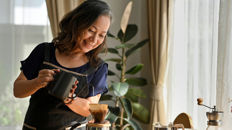 Smiling woman making coffee