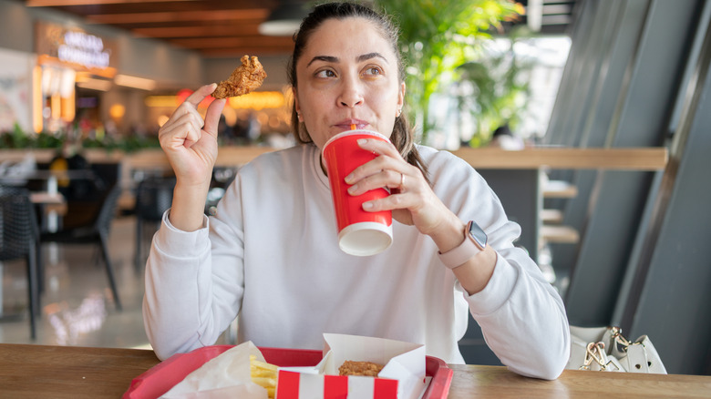 Woman eating fast food at the mall