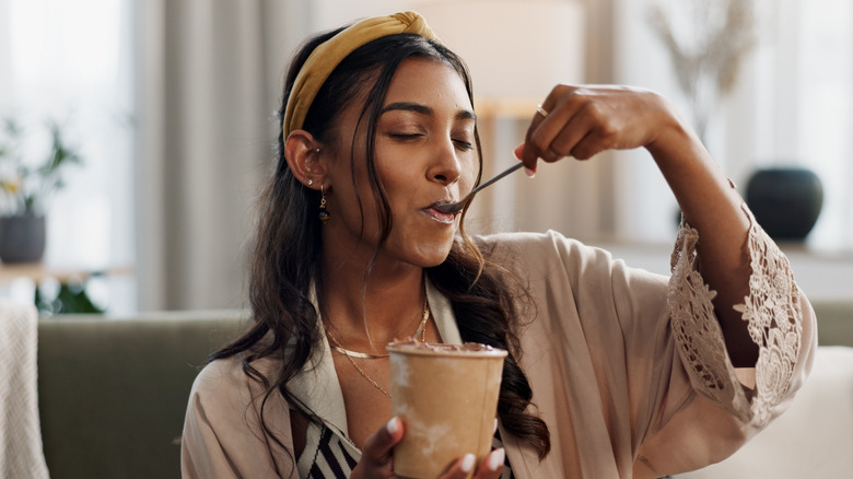 Woman eating ice cream from pint