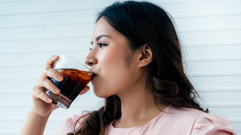 Woman drinking soda from a glass