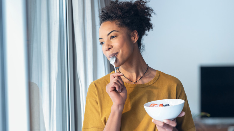 Woman smiling while eating cereal