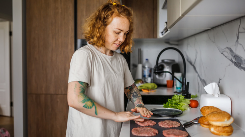 Woman cooking burgers at home