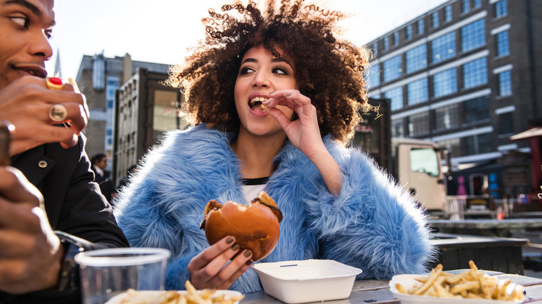 Woman eating French fries with a friend