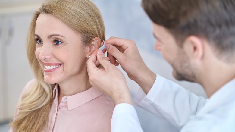 A woman is fitted for a hearing aid