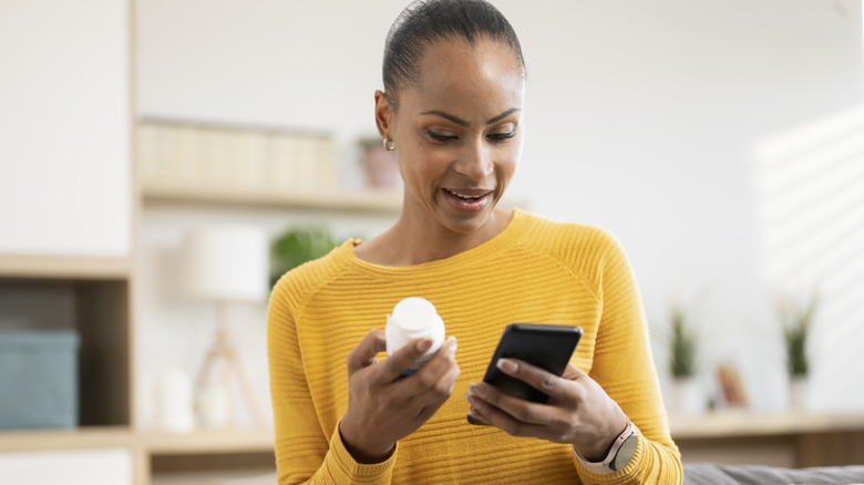 woman checking her medication information on her smartphone