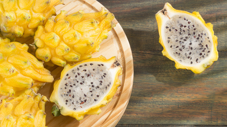 cut and uncut yellow dragon fruit with white flesh