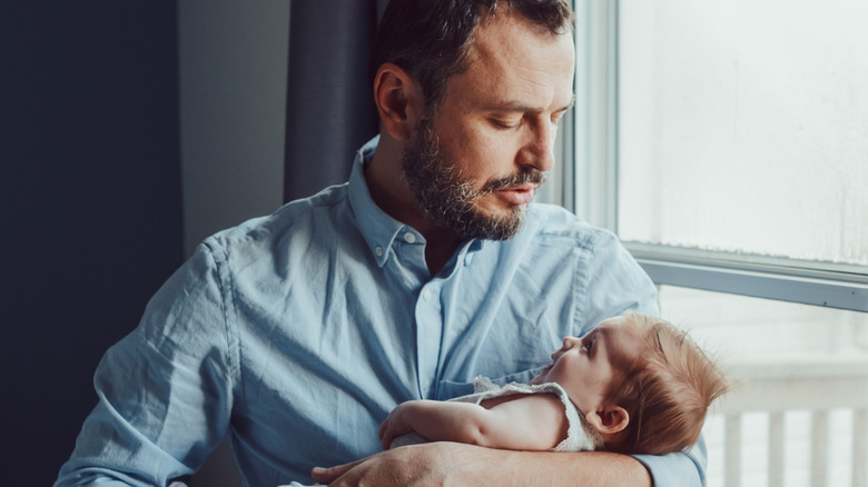 Man rocking smiling baby