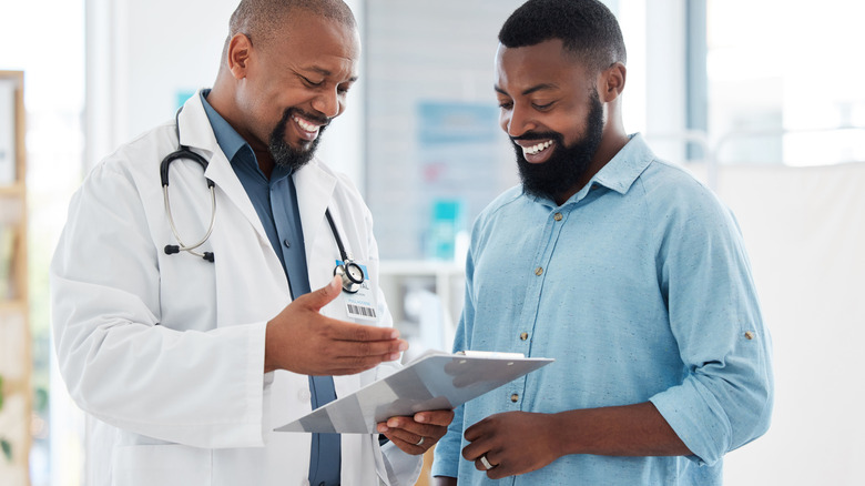 A doctor giving good news to a male patient