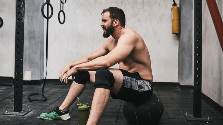 A man sweating after intense exercise in a gym