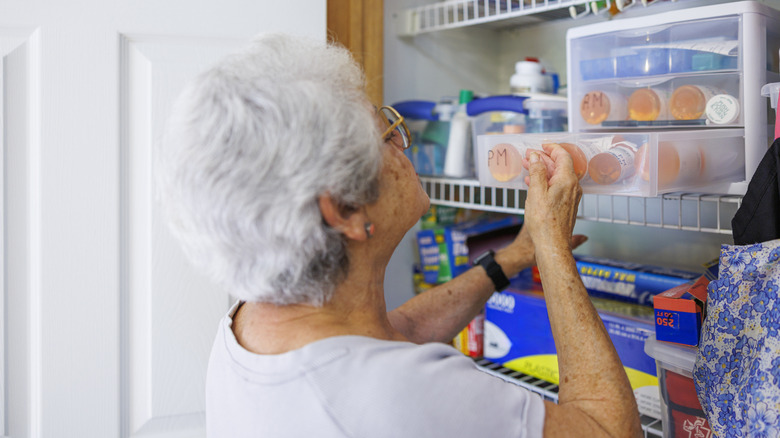 Woman looking in medicine cabinet