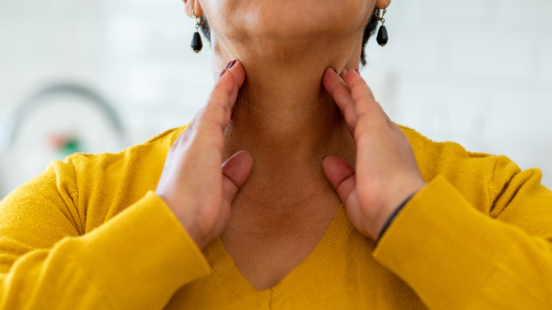 Woman touching swollen neck glands