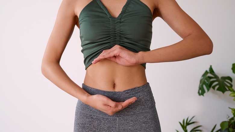 woman cupping stomach with hands 