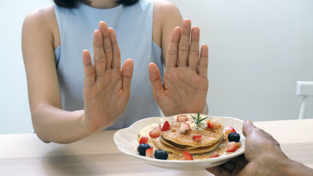 Woman turning down crepes with fruit