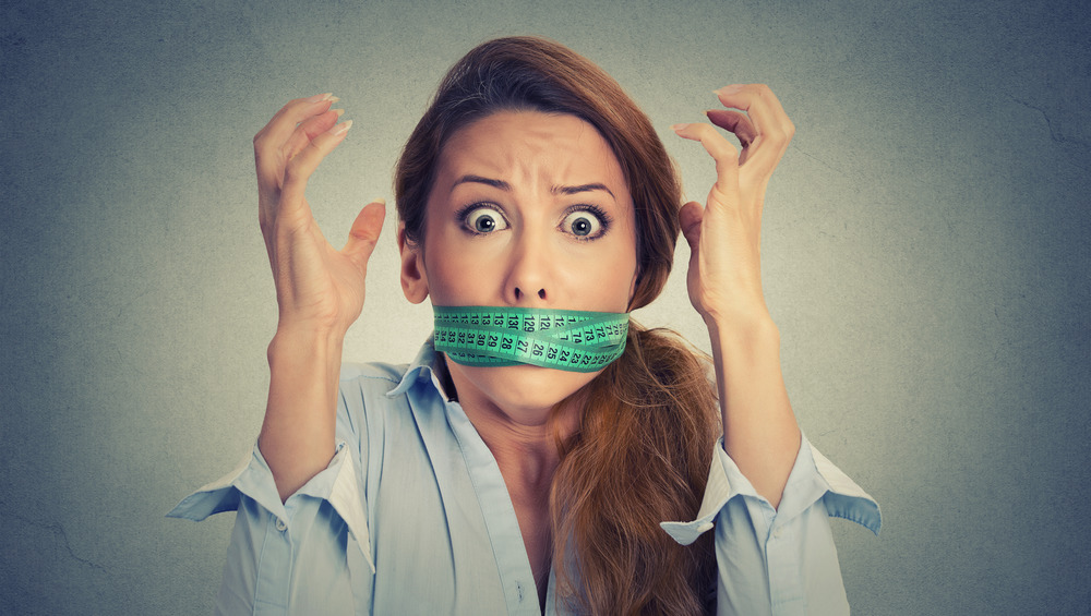 Woman with her mouth taped shut, looking frazzled
