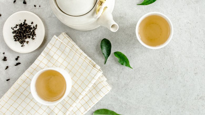 Cups of green tea on white