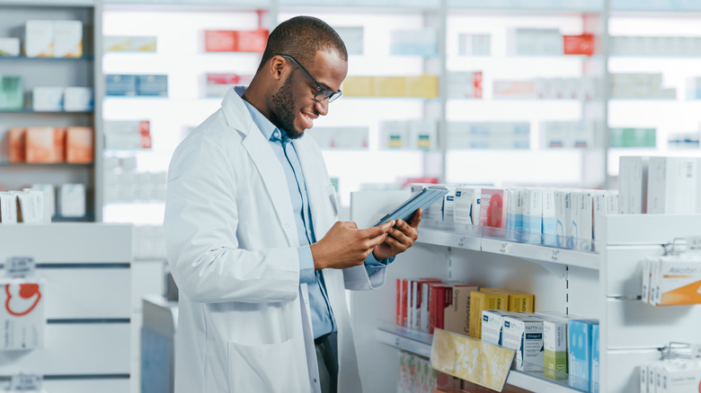 Pharmacist checking tablet in pharmacy