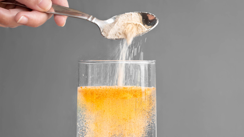 Person pouring powder into water