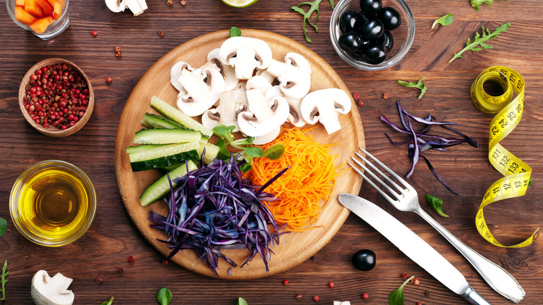 Shredded vegetables on a wood table with a tape measure