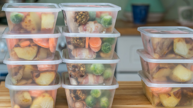 Filled meal prep containers stacked up, containing meals and snacks