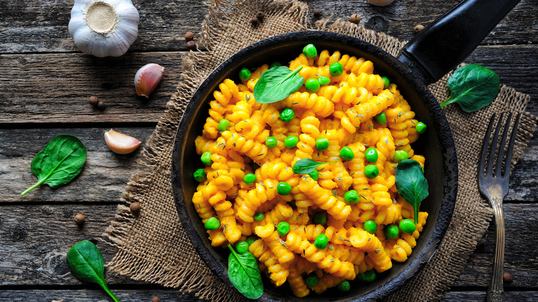 plant-based mac and cheese in a skillet with peas