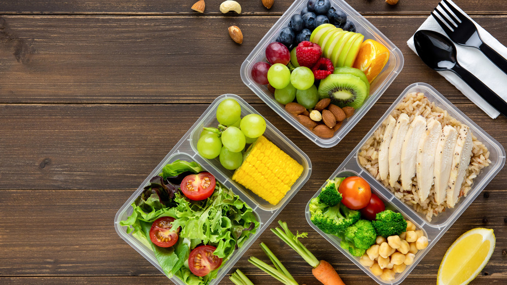 Healthy food in lunchboxes on a wood table